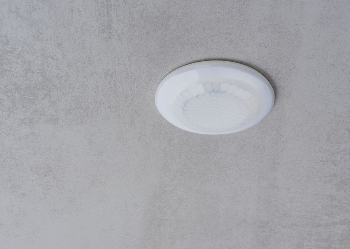 Détecteur de présence blanc 360°. IP 54. Contact renforcé 10 A. LED = max 400W. Montage encastré plafond. Détection Diamètre 10 m à 2.5 m de haut. Réglage TEMPO 15 sec-30 min + impulsion. Réglage possible via télécommande. Réf. 1030052