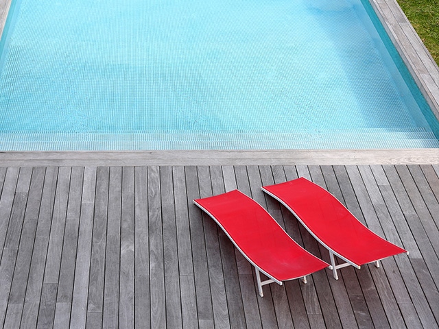 Terrasse en bois devant une piscine