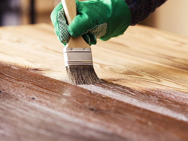 Passage d'un produit sur parquet avec un pinceau