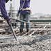 Ouvriers coulant du béton sur une armature de plancher en acier